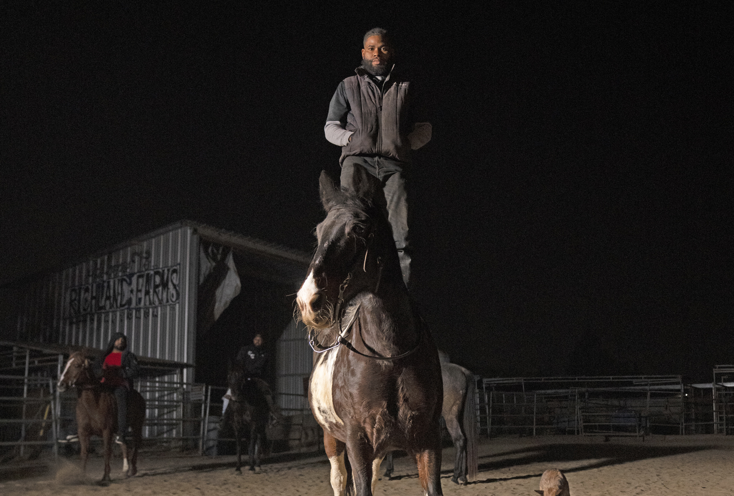 Compton Cowboys man standing on horse at night